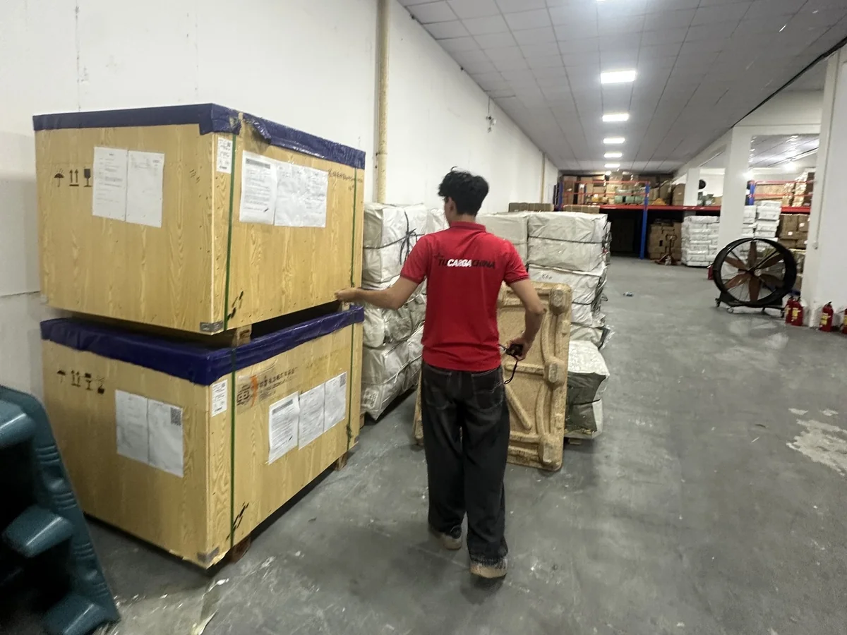 Colaborador de TUCARGACHINA junto a mercancía embalada en la bodega de Foshan